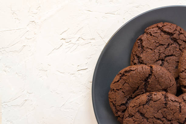 istock Top view, chocolate chip cookies on a black plate. white concrete background. From above. copy space 1208308337