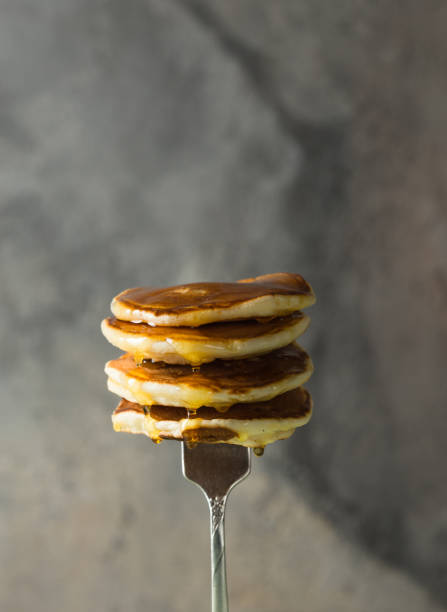 istock Stack of pancakes on fork with honey. Stack of pancakes lavitation 1208308600