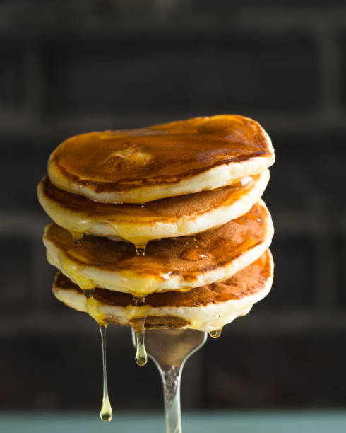 istock Stack of pancakes on fork with honey. Stack of pancakes lavitation 1208308611