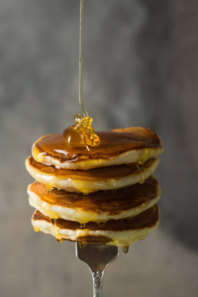 istock Stack of pancakes on fork with honey. Stack of pancakes lavitation 1208308615