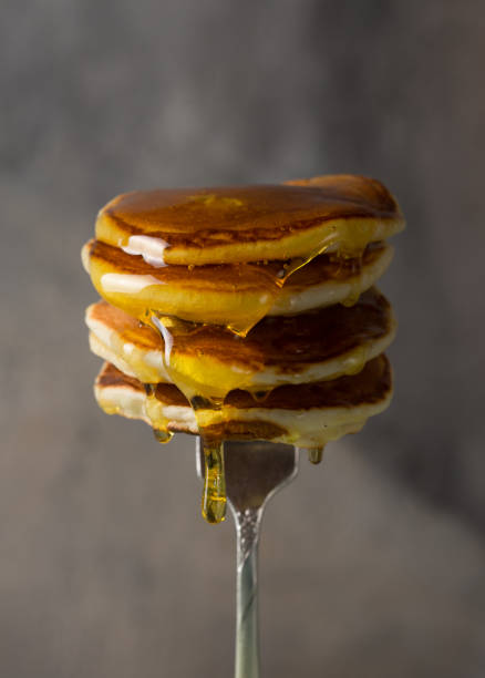 istock Stack of pancakes on fork with honey. Stack of pancakes lavitation 1208308624
