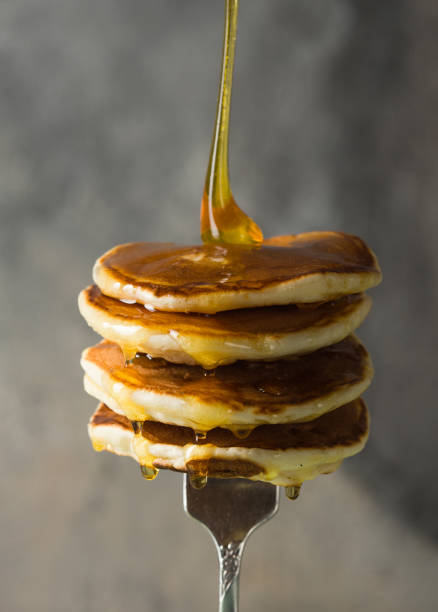 istock Stack of pancakes on fork with honey. Stack of pancakes lavitation 1208308627