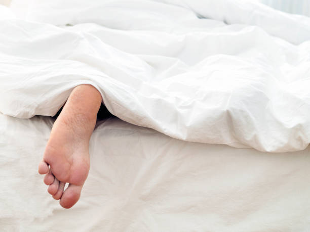 istock Lazy man and his feet ,  lying  on comfortable bed 1208308628