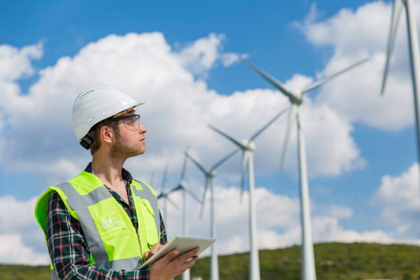istock Young engineer man looking and checking wind turbines at field 1208308630
