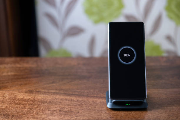 istock smartphone wireless charging on charging stand on wooden table 1208309259