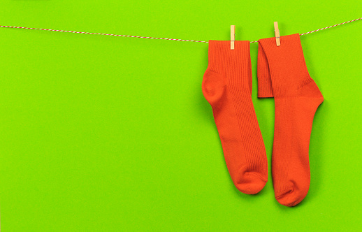 colorful   socks hanging on a rope on green   background