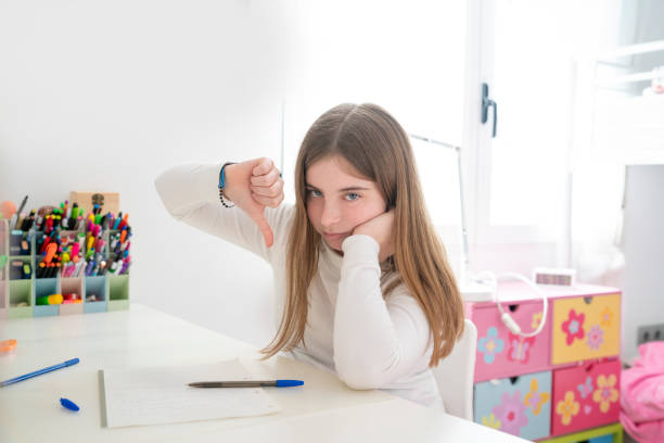 boring homework pictures Student teenager girl negative finger down hand sign Student teenager girl negative finger down hand sign at her bedroom desk boring homework twelve stock pictures, royalty-free photos & images