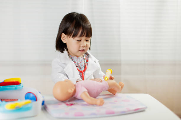 istock Cute Doctor Playing With Toys On Table 1208313373