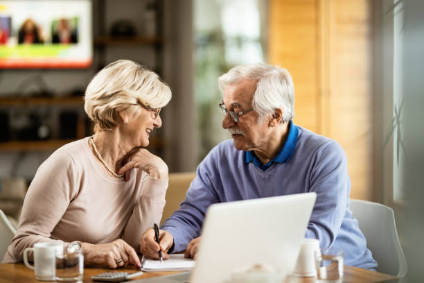 istock Happy senior couple communicating while making plans about their home budget. 1208314451