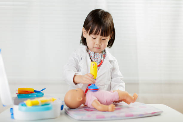 istock Cute Doctor Playing With Toys On Table 1208314511