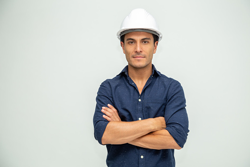 Guapo hombre ingeniero industrial con un casco blanco consollado sobre fondo blanco photo