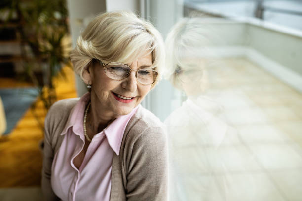 istock Smiling senior woman relaxing by the window. 1208318866