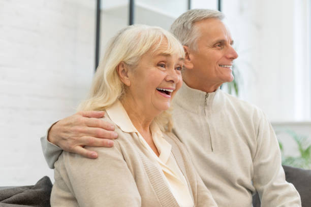 istock Smiling elderly couple resting on sofa in living room 1208318967
