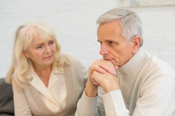 istock Sad older woman looking at her husband at home 1208320178