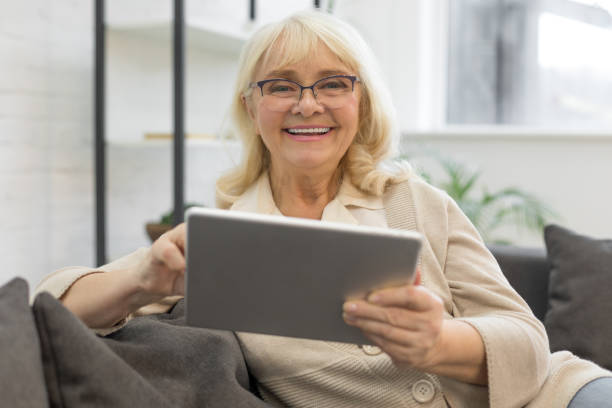 istock Pretty older woman looking at gadget screen at home 1208320995