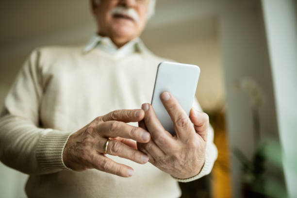 istock Close-up of mature man using smart phone. 1208323812