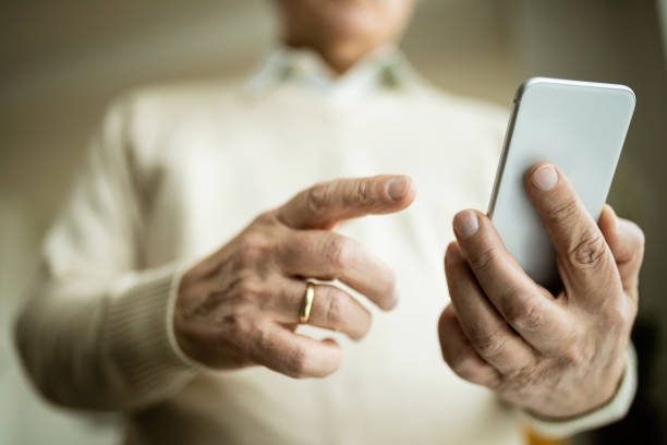 istock Close-up of mature man text messaging on cell phone. 1208324890