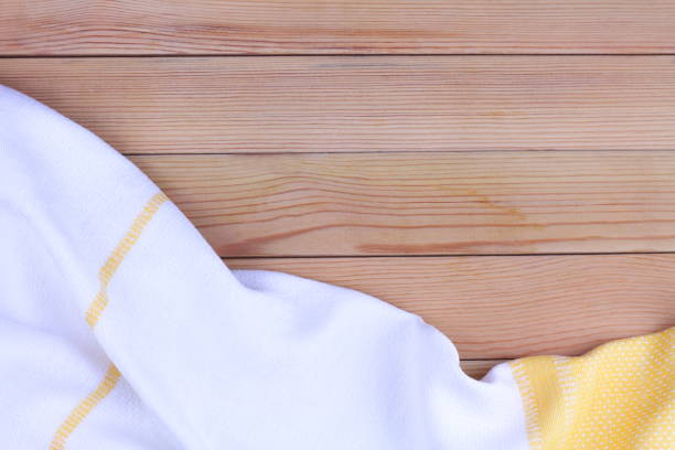 istock White, yellow towel on wooden kitchen table. View from above with copy space for text. 1208325233