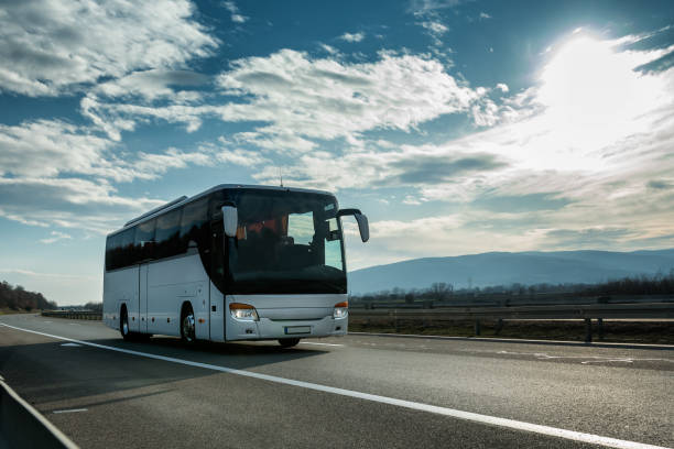 istock White Modern tourist bus driving through highway on bright sunny sunset 1208326593