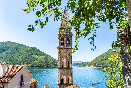 Belltower of Saint Nicholas church in Perast with the view on sea and mountains, Montenegro