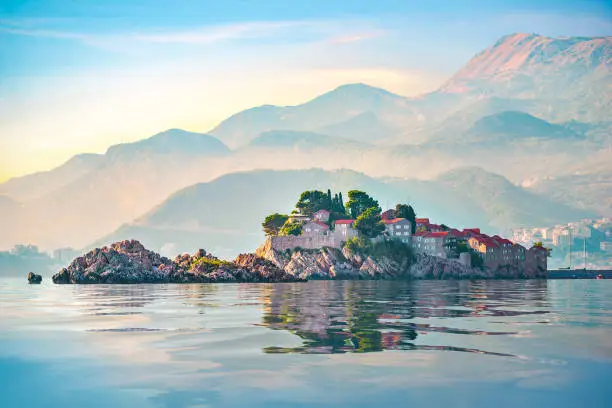 Sveti Stefan and mountains in Adriatic sea at sunset, Montenegro