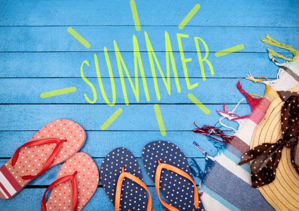 istock Flip-flops, hat and beach towels on wooden table. Summer concept. 1208326990