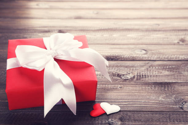 istock Gift box with ribbon and hearts on wooden table 1208327102