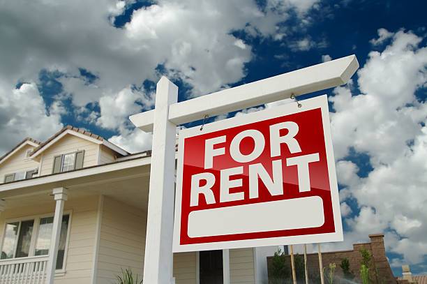 Red and white For Rent sign in front of house stock photo