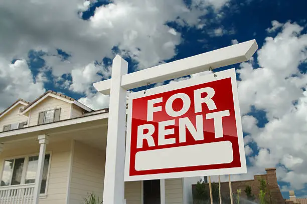 Photo of Red and white For Rent sign in front of house