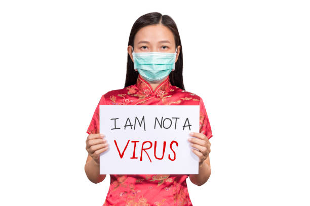 身著中國服裝的亞洲婦女戴著衛生面具，手持標誌我不是反種族主義，欺淩和仇恨在冠狀病毒2019感染或covid-19的爆發情況的virus - fury 個照片及圖片檔