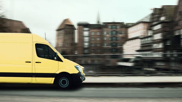 istock Fast parcel delivery, yellow mail van in a historic small town. 1208328657