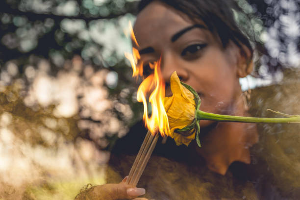 istock Young woman holding a burning tinder and rose 1208329646