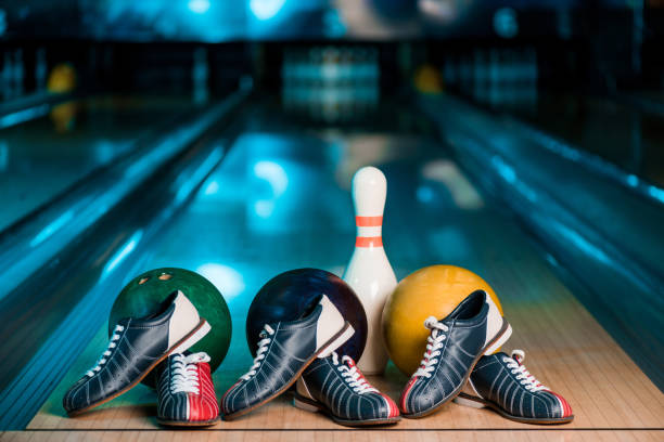 selective focus of bowling shoes, balls and skittle on skittle alley in bowling club selective focus of bowling shoes, balls and skittle on skittle alley in bowling club bowling alley stock pictures, royalty-free photos & images