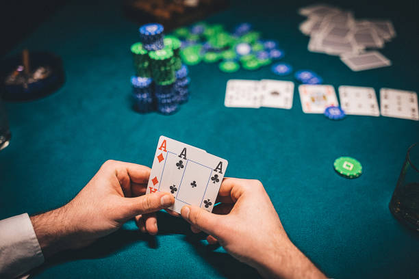 Man holding two aces in poker game One man, gentleman playing poker in dark room at night, man holding two aces. texas hold em photos stock pictures, royalty-free photos & images