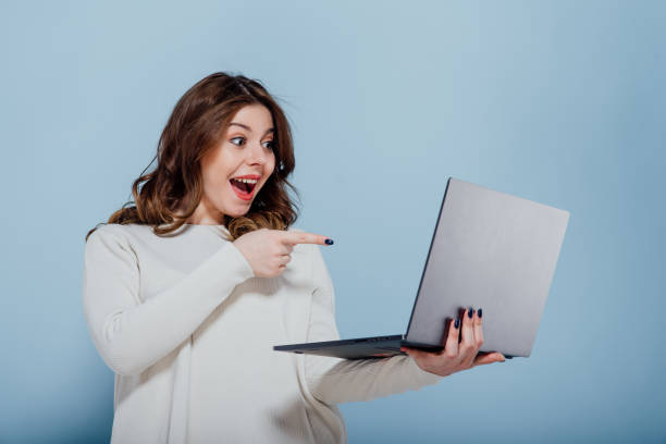istock Excited plump woman surfing Internet on laptop 1208333905
