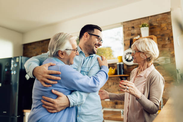 istock Cheerful man having fun while greeting his mature parents in the kitchen. 1208333961