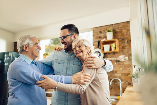 istock Happy man embracing his senior parents while visiting them at home. 1208334208