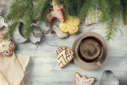 Cup of black coffee with Christmas tree and gingerbread cookies, top view