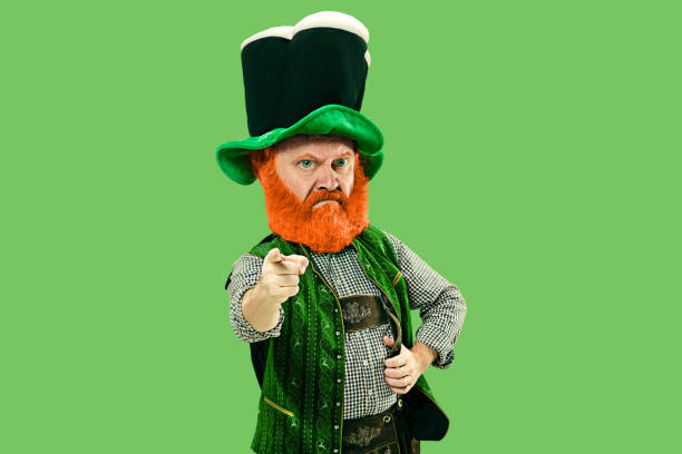 istock Excited leprechaun in green suit with red beard on white background 1208335634