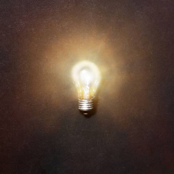 istock Glowing light bulb. Realistic image of included tungsten light bulb on gray background, top view. Creative idea concept 1208335950