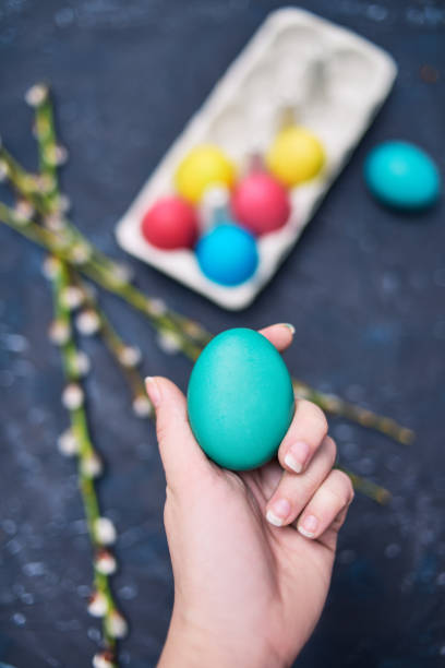 istock Happy Easter. Painted multi-colored. The girl holds an empty colored egg, a place for text, a picture. Girl shows a colored egg. Blossoms of pussy-willow seals 1208340100
