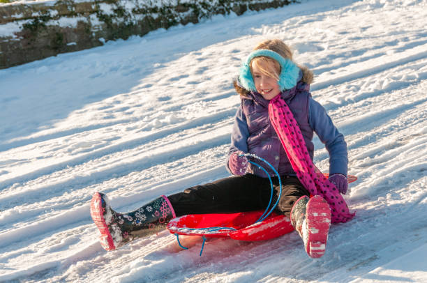 istock Happy young vibrantly dressed girl sledging with blue ear muffs 1208341430