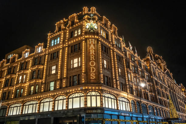 Harrods department store in London at night London, United Kingdom - November 23, 2019: The famous Harrods department store in the evening  at Knightsbridge in London, UK. Harrods is the biggest department store in Europe and offers over one million square feet of retail space, acting as a magnet for rich clients and numerous tourists throughout the year. harrods photos stock pictures, royalty-free photos & images