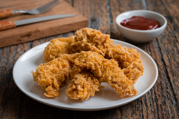 Crispy fried breaded chicken strips on plate and ketchup Crispy fried breaded chicken strips on plate and ketchup chicken finger stock pictures, royalty-free photos & images