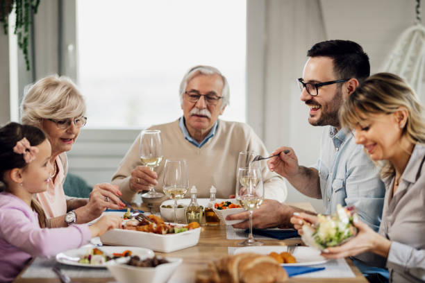 istock Happy extended family enjoying in lunch at dining table. 1208342831