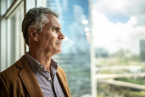 istock Mature businessman looking out of window 1208343034