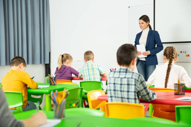 istock Friendly teacher with children during lesson 1208344361