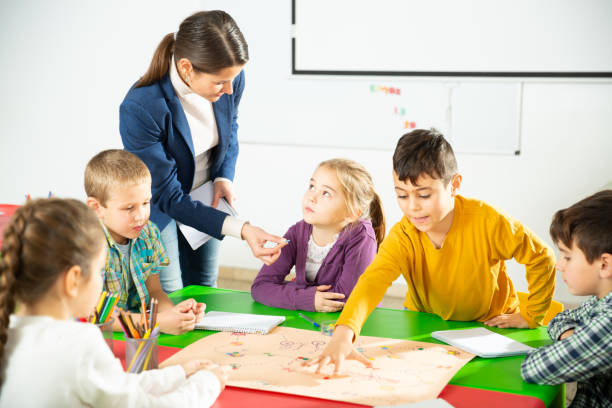 istock Kids and teacher playing educational board game 1208344403