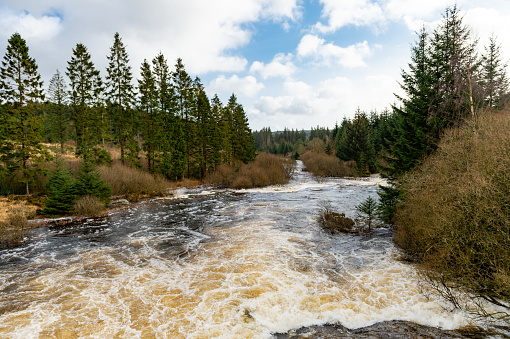 A river in full spate after a dam up stream overflowed due to heavy rainfall.\nThe river is in Dumfries and Galloway, south west Scotland.