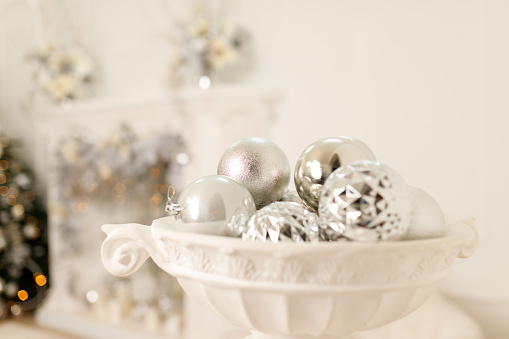 Christmas silver balls in old pot on white background. Composition with Brilliant Christmas Balls.